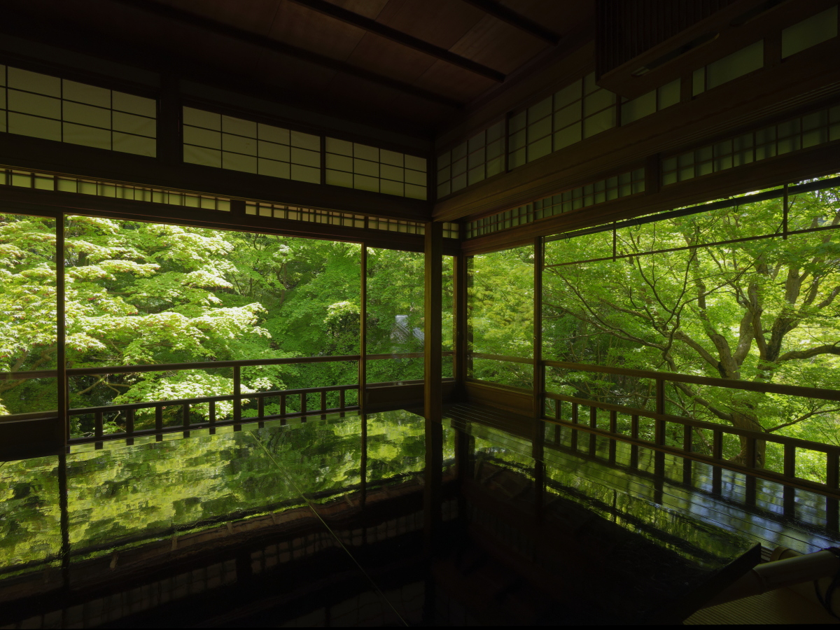 京都の瑠璃光院　窓から見える新緑が写経机に映り込む